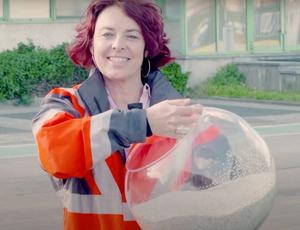 Veolia-collega houdt bokaal met gerecycleerde pellets vast